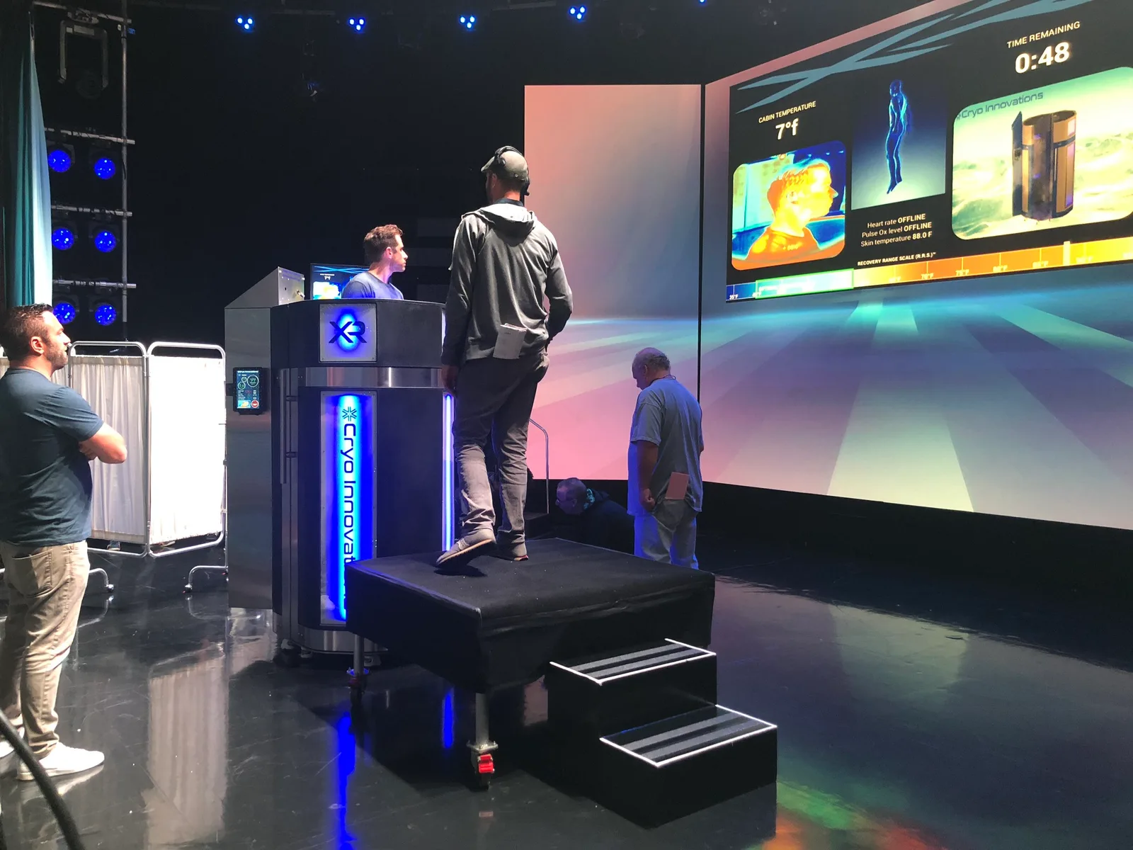 The XR chamber on its platform on the Ellen stage, the studio screen showing the chamber display